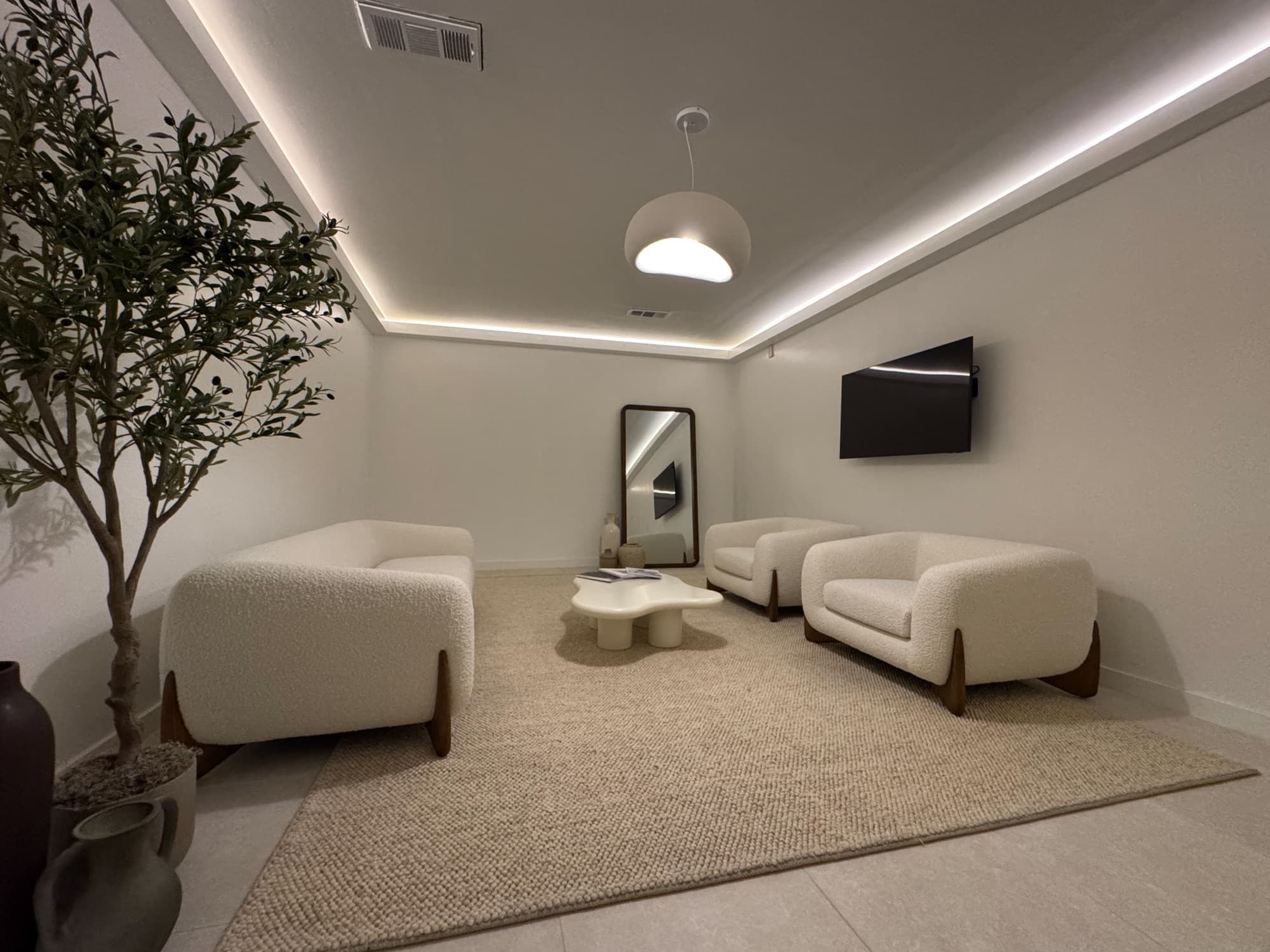 Ora's lounge in the evening — warm cove light and boucle chairs